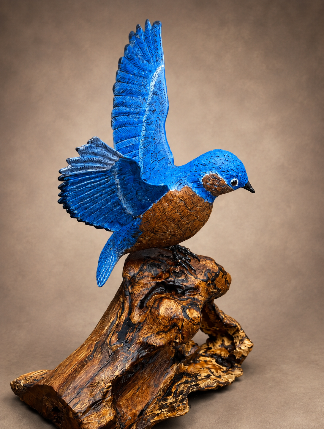 Eastern bluebird wildlife sculpture with wings raised on a carved wood base