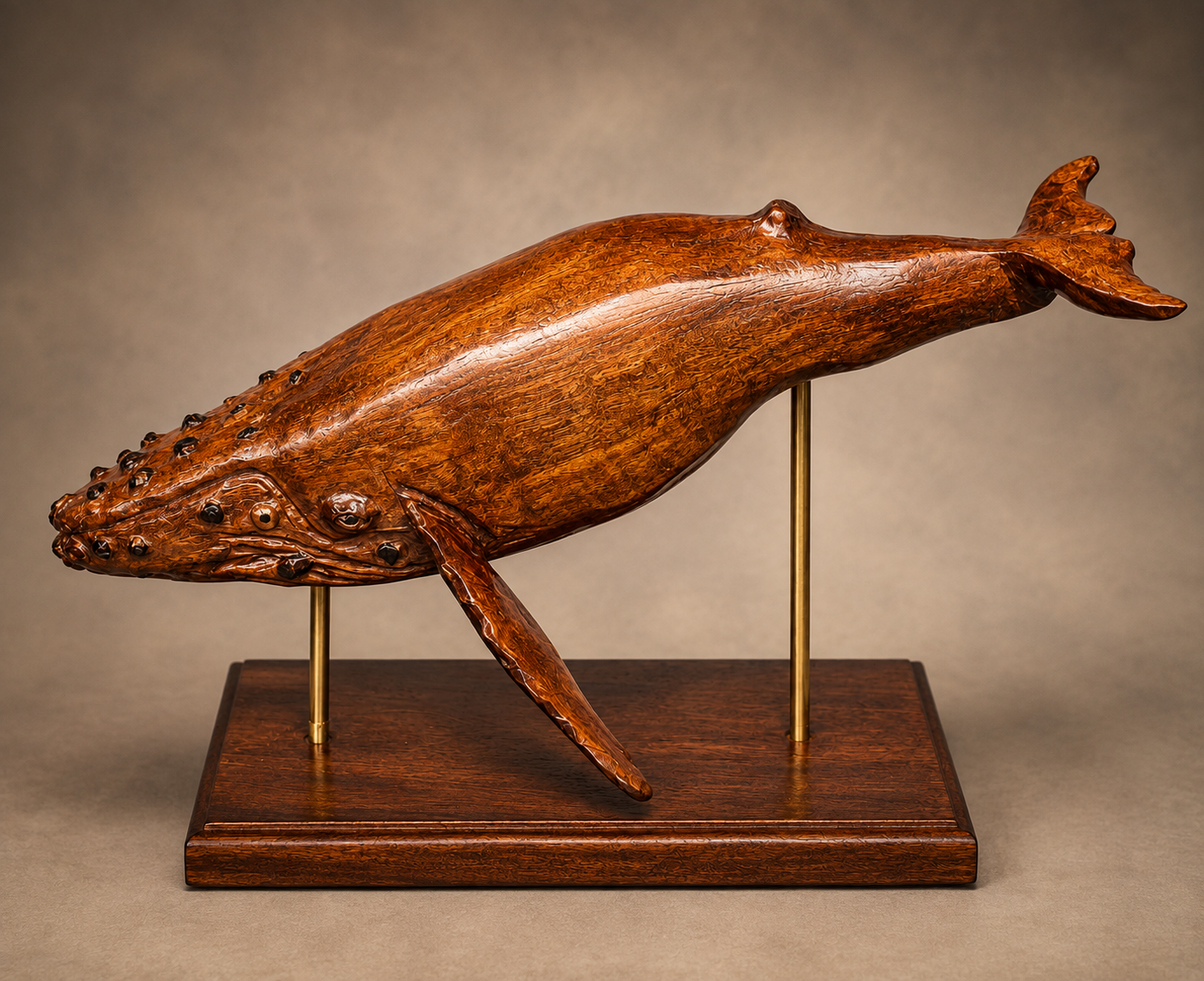 Humpback whale sculpture carved from cherry wood on a display stand