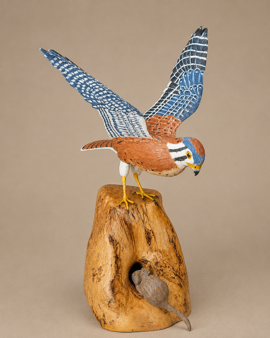 American kestrel wildlife sculpture in flight above a carved wooden base